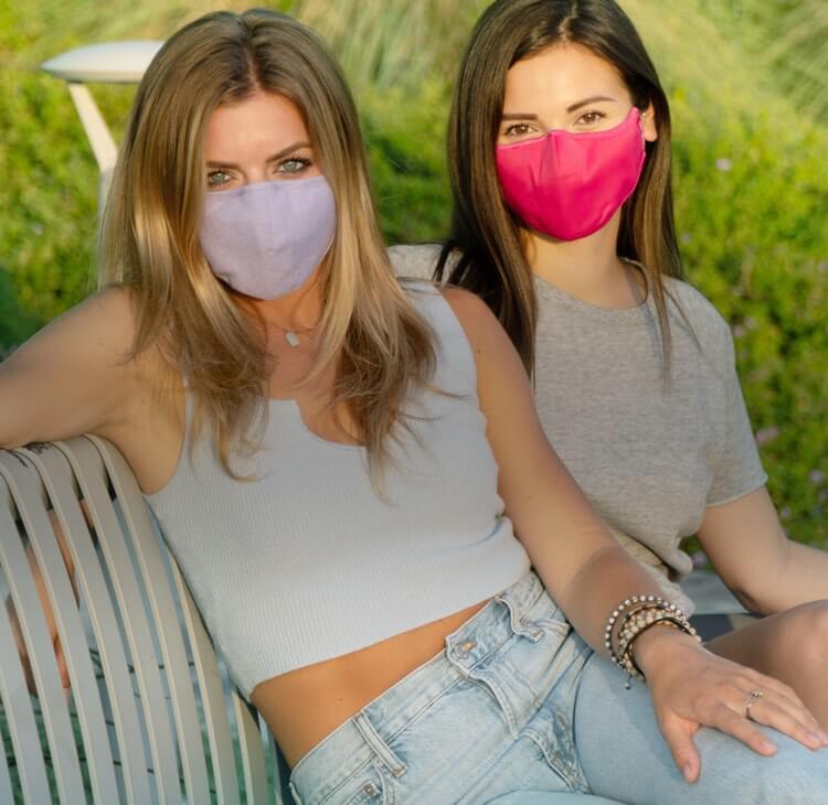 2 Girls in masks sitting on bench